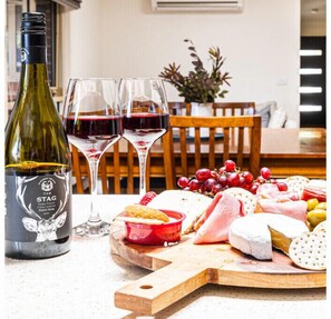 Guests can enjoy a wine and cheese selection on a wooden board.