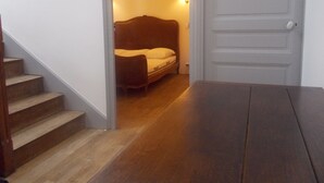 Eine Treppe führt zu einem Schlafzimmer mit einem Bett und einem Nachttisch.