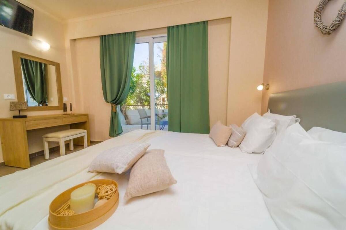 A hotel room with a bed, a desk, a chair, and a window with curtains.