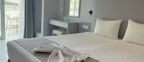 Una habitación de hotel moderna con una cama grande, un escritorio y un balcón.