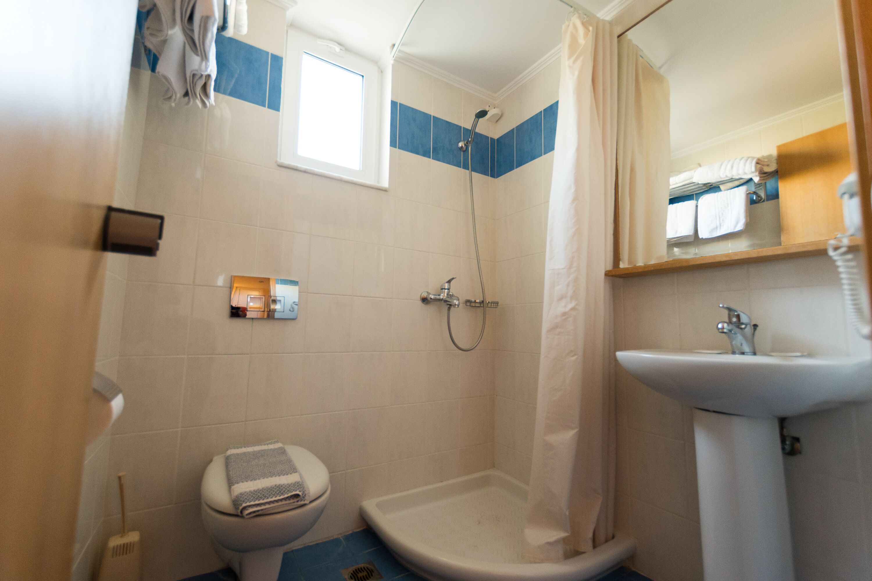 Un baño con ducha, inodoro y lavabo.