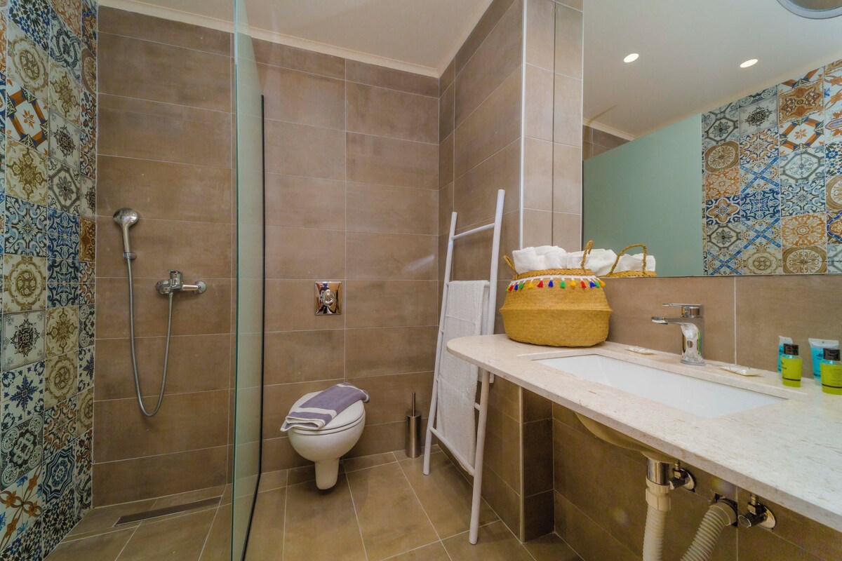 A bathroom with a shower, toilet, and sink.