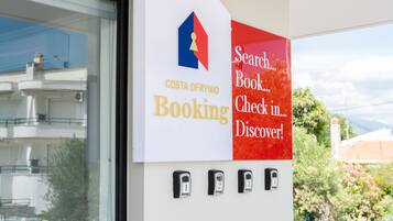 Un letrero de Costa Ofrynio Booking con un logotipo, una barra de búsqueda, opciones para reservar, registrarse y descubrir, y tres teclados numéricos.