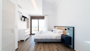 Un dormitorio moderno con una cama grande, una mesita de noche, un televisor y vistas al exterior.