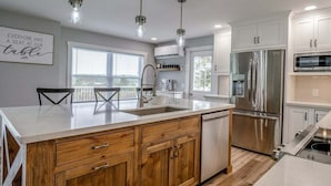 Una cocina moderna con una isla grande, electrodomésticos de acero inoxidable y armarios de madera.