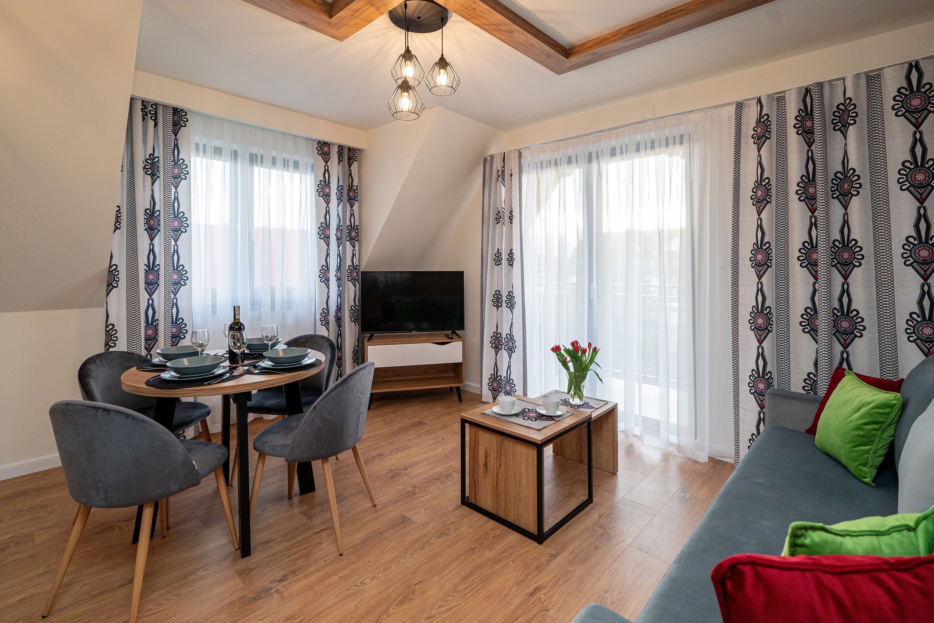 A living room with a dining area, a TV, and a sofa.