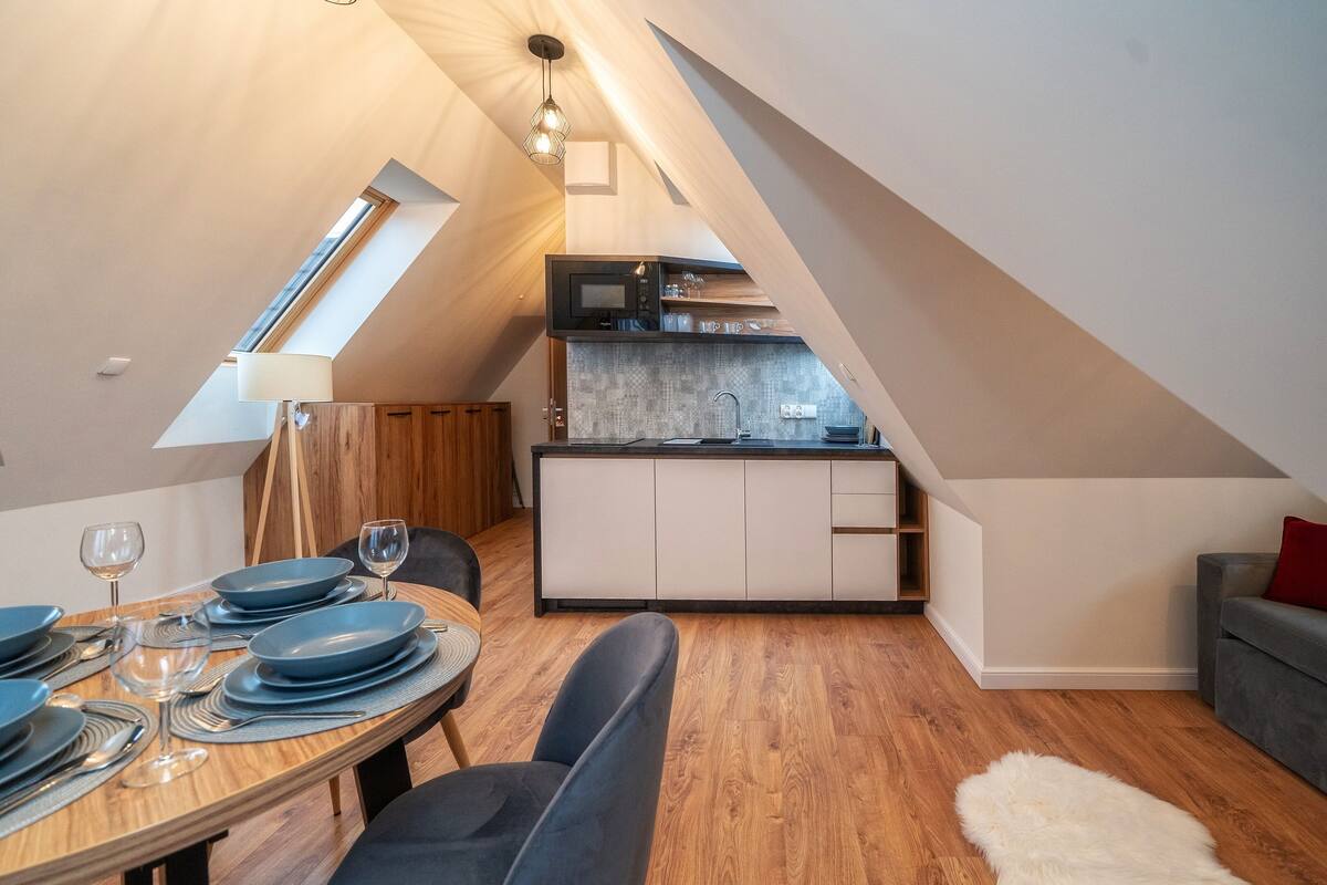 Um loft moderno com área de jantar, cozinha e sala de estar.