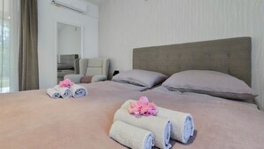 Habitación de hotel con una cama grande, dos almohadas, una silla y un espejo.