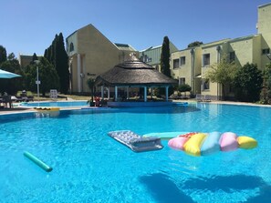 A swimming pool with lounge chairs and a gazebo.