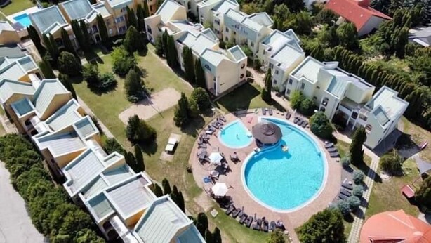 A residential complex with multiple apartment buildings, a central swimming pool, and surrounding greenery. - LB - Phoenix Apartman Siófok (Siófok)