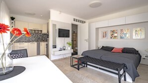 Un dormitorio moderno con una cama grande, un escritorio y una televisión.