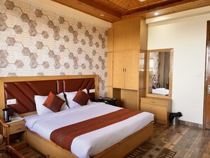 A neatly arranged bedroom with a large bed, wooden wardrobe, and a mirror.