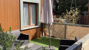 A wooden building with a window and an outdoor seating area with a table and chairs. - La Campagne Proche de Paris - Chez Marie-louise (Montreuil)