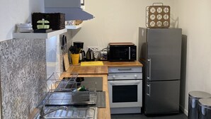 A compact kitchen with a sink, stove, microwave, and refrigerator. - La Campagne Proche de Paris - Chez Marie-louise (Montreuil)