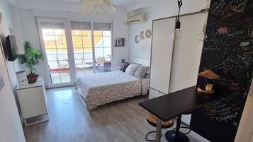 Een moderne slaapkamer met een bed, een bureau en een prikbordwand met teksten.