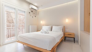 Een moderne slaapkamer met een houten bed, een nachtkastje en uitzicht door een schuifdeur.