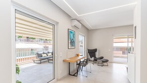 Een moderne woonkamer met een houten tafel, een grijze fauteuil en een bank.