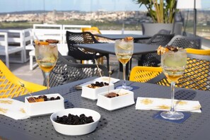 Una terraza en la azotea con mesas, sillas y fuentes de comida.
