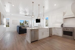 Enjoy cooking in this well-equipped kitchen with a central island, white cabinetry, and stainless steel appliances.