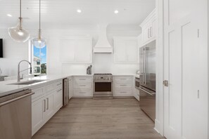 Enjoy cooking in this well-lit kitchen with sleek cabinetry, a refrigerator, and oven.