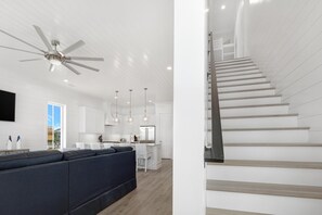 Stunning living area with a sleek staircase, comfortable sofa, and modern kitchen.