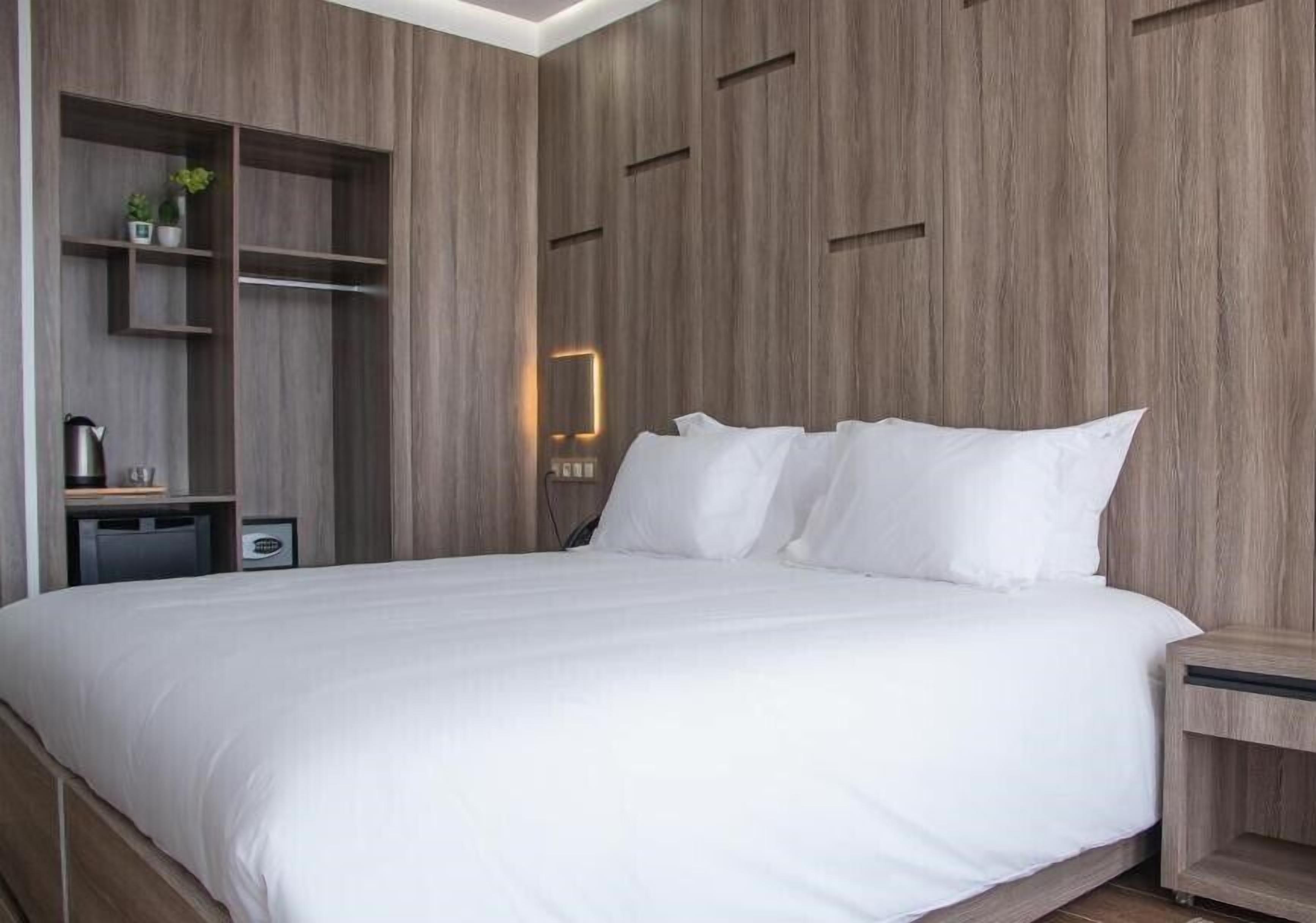 Un dormitorio con una cama grande, estanterías empotradas y una mesita de noche.