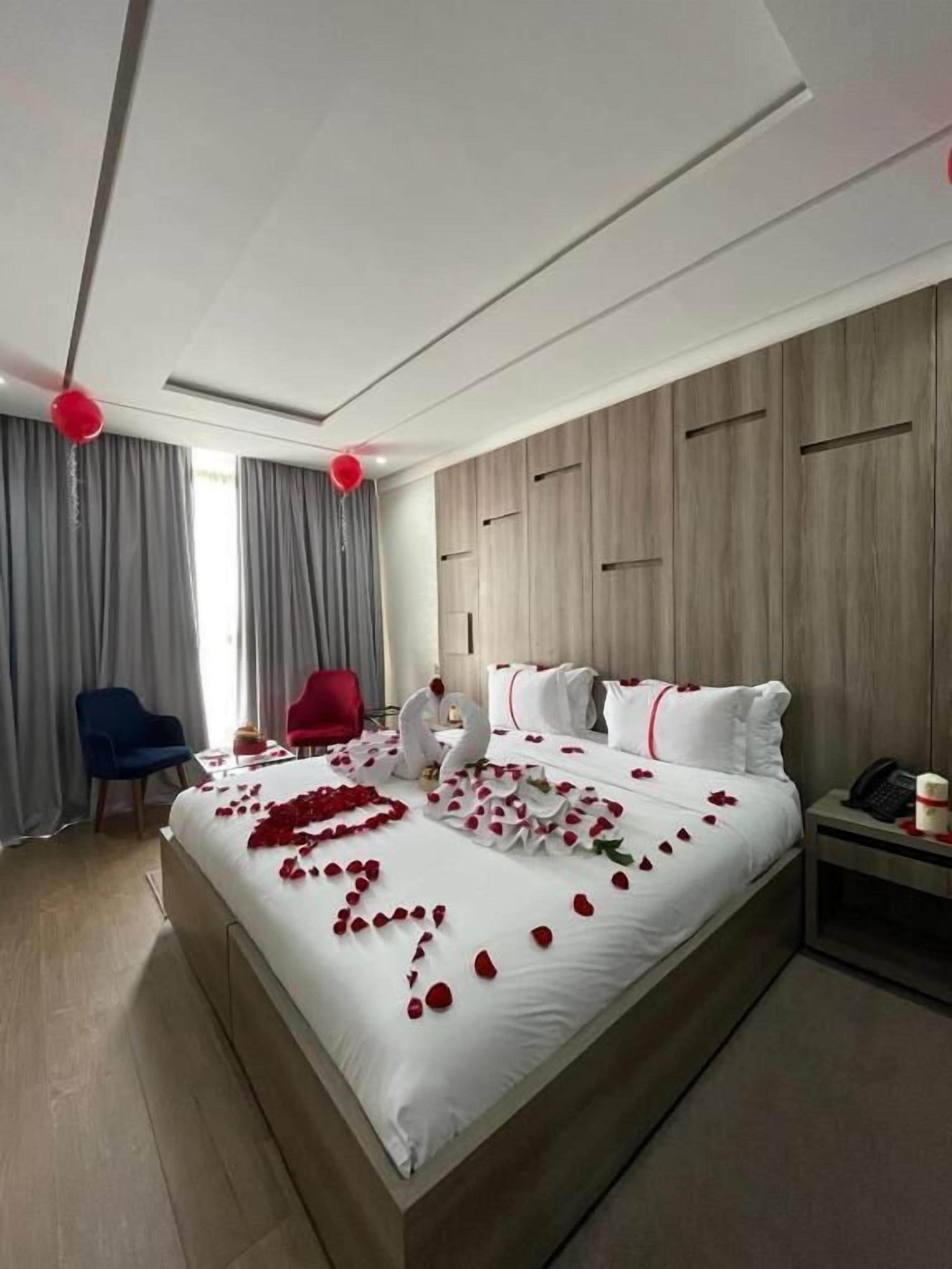 Une chambre d’hôtel avec un grand lit, un bureau, une chaise et une armoire.