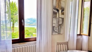Ein Zimmer mit Blick auf einen See und Berge, inklusive Heizkörper, Tisch und Stuhl.