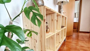 Ein Flur mit einem Holzkonsolentisch, einer Topfpflanze und einer Lampe.