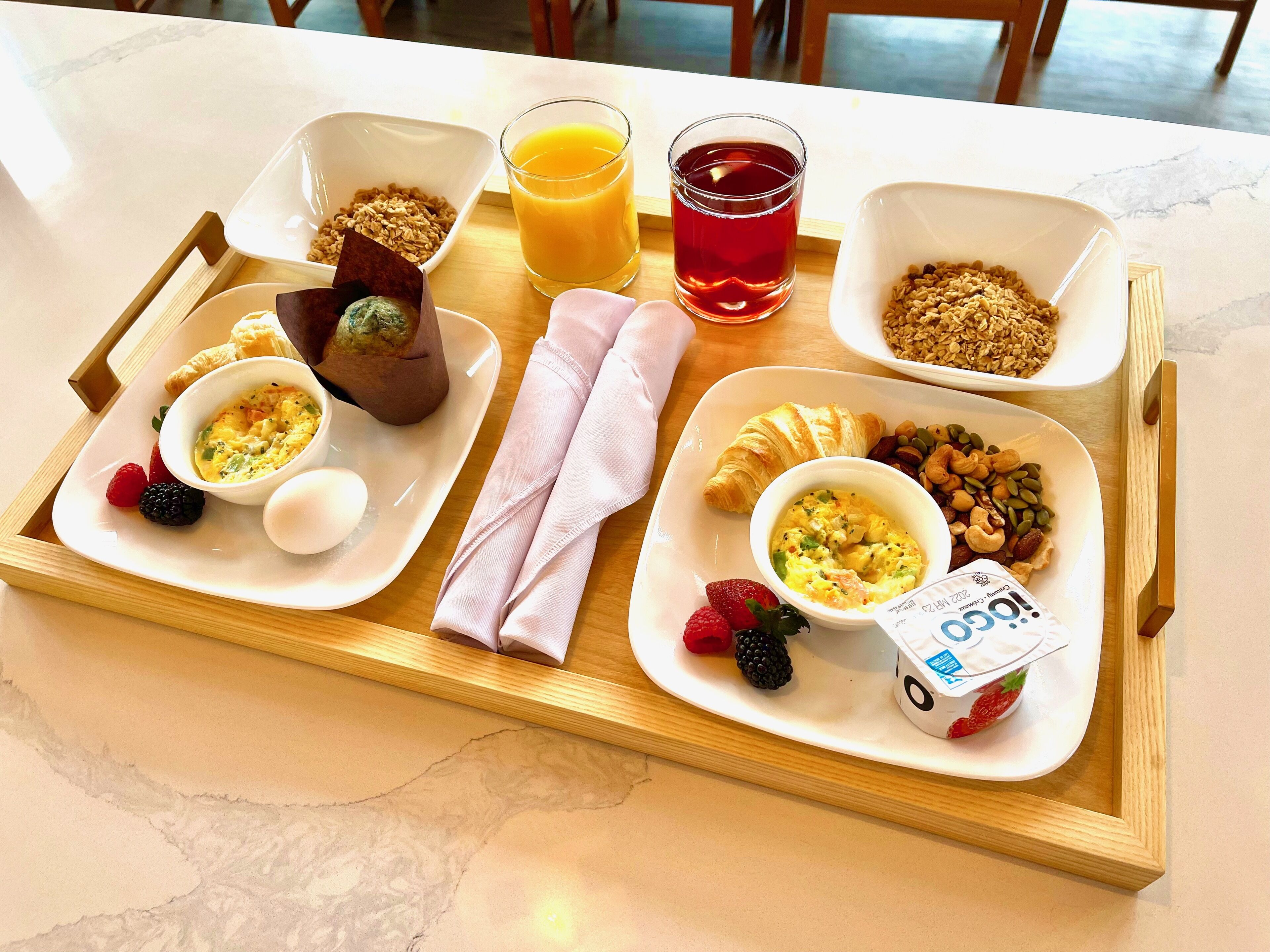 A breakfast tray with various food items and drinks.