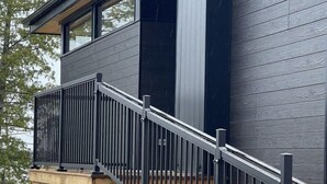 A modern building with a wooden deck and a black metal railing. - Evo B&B - Adults Only, Waterfront (Northern Bruce Peninsula)
