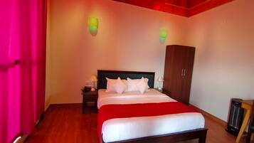 A bedroom with a wooden bed, a nightstand, a wardrobe, and a red curtain.