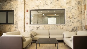 Una sala moderna con un sofá seccional color beige, una mesa de centro negra y un ventanal con vistas al interior.
