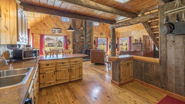 Een rustiek houten interieur met een ruime keuken en een eethoek.