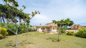 A residential property with a well-maintained lawn, a patio area, and a house with a tiled roof. - Mercedes: Beautiful detached house with a large garden (L'Escala)