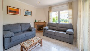 A living room with two grey sofas, a patterned coffee table, and a fireplace. - Mercedes: Beautiful detached house with a large garden (L'Escala)