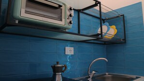 Une cuisine équipée d’un grille-pain encastré, d’une machine à café et d’un évier.