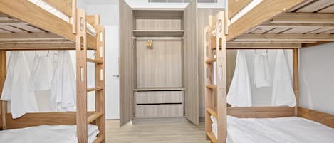 Ein Zimmer mit Etagenbetten, einem Kleiderschrank und einer Dusche.