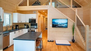 Un'ampia cucina con mobili bianchi, un'isola grande e un'area pranzo.