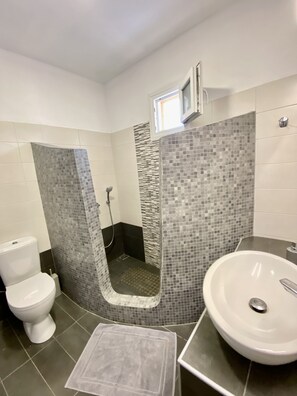 Deluxe villa | Badkamer | Een douche, een haardroger, pantoffels, handdoeken