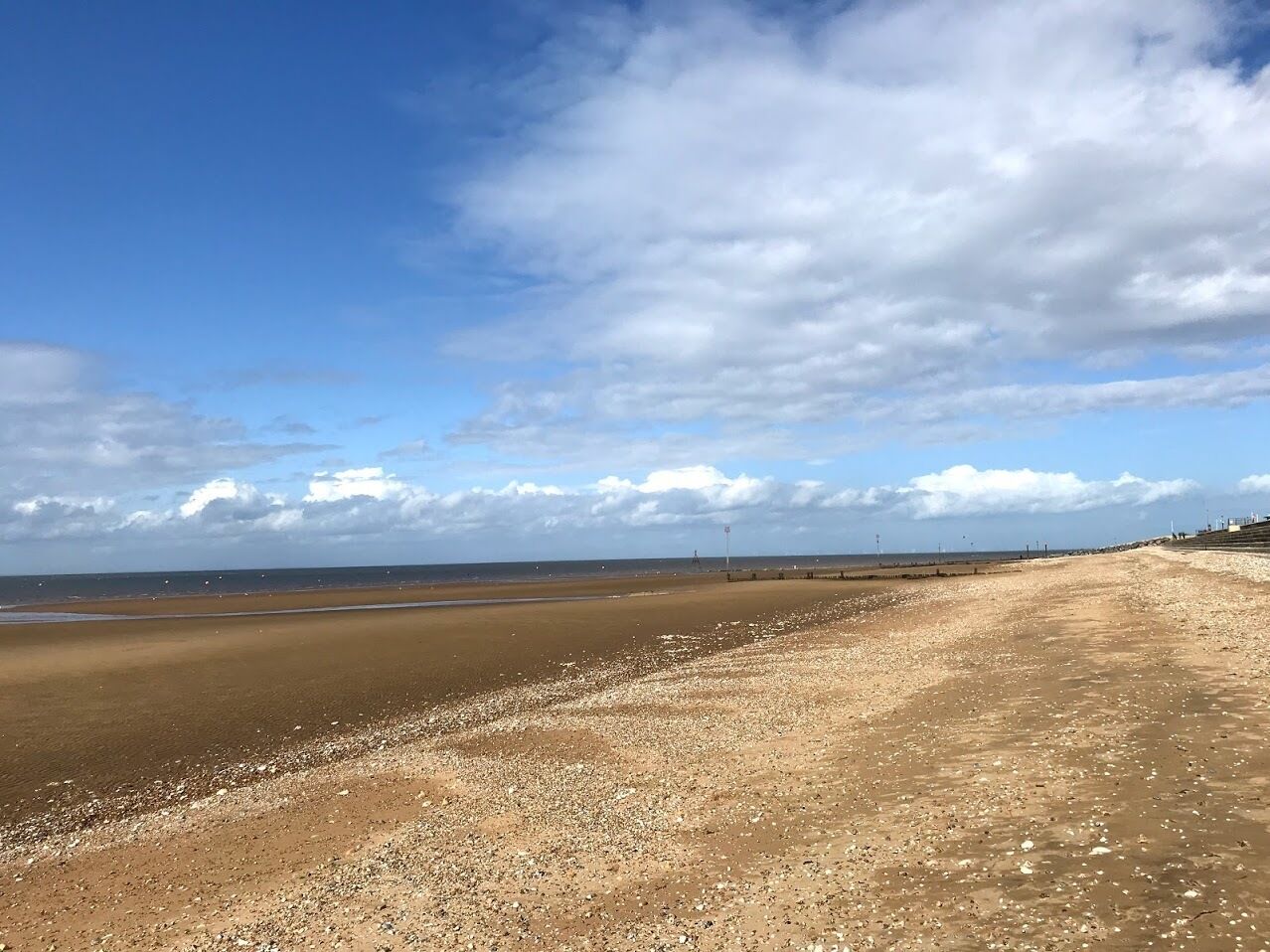 Une vaste plage, un ciel dégagé et un horizon lointain.