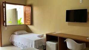 A hotel room with two beds, a desk, a chair, a TV, and a small trash bin. - Hotel do Carmo (Piracuruca)