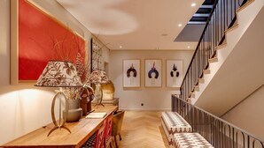Un intérieur moderne avec une table à manger en bois, des chaises, un banc et un escalier.