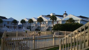A waterfront hotel with multiple balconies, palm trees, and a pool area. - Charter Landing II unit C9 Luxury Waterfront Condo in Orange Beach.
 (Orange Beach)