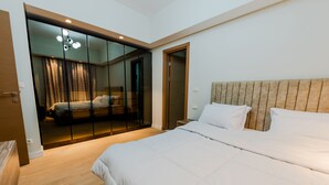 A modern bedroom with a large bed, a glass wardrobe, and a wooden floor. - Luxury doublex apartments in new cairo
شقق فندقيه للايجار بالتجمع الخامس  (Cairo)