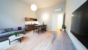 A modern living room with a sofa, coffee table, and dining area. - Karl BY ZEITRAUM (Prague)