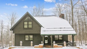 A two-story cabin with a steeply pitched roof, a front porch, and a covered entryway. - Sunrise Dacha: 3  BR, 2.5  BA House in Canaan Valley, Sleeps 10 (Davis)