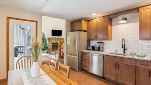 A modern kitchen with wooden cabinets, a stainless steel refrigerator, and a granite countertop. - Sunrise Dacha: 3  BR, 2.5  BA House in Canaan Valley, Sleeps 10 (Davis)