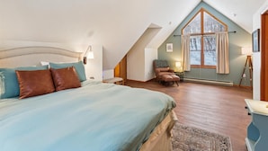 A bedroom with a large bed, a chair, a window with curtains, a ceiling fan, and a radiator. - Sunrise Dacha: 3  BR, 2.5  BA House in Canaan Valley, Sleeps 10 (Davis)