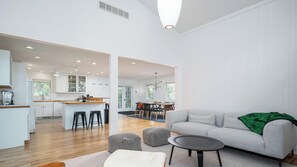A modern living room with a grey sofa, ottomans, and a coffee table. - Tate House (Saugatuck)